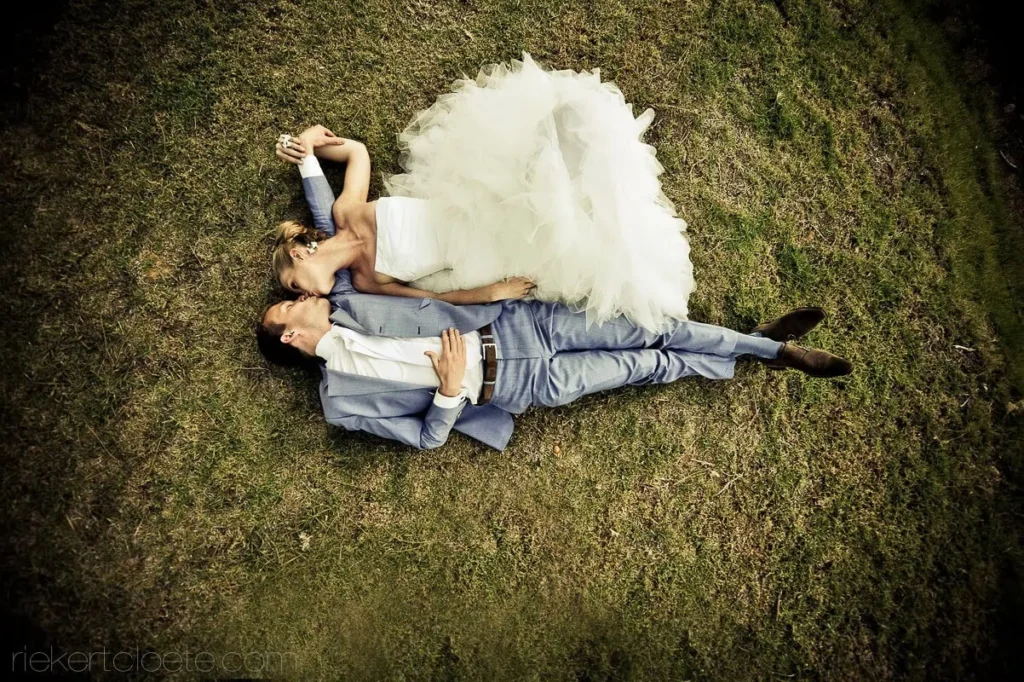 couple lying on grass aerial view full tulle gown