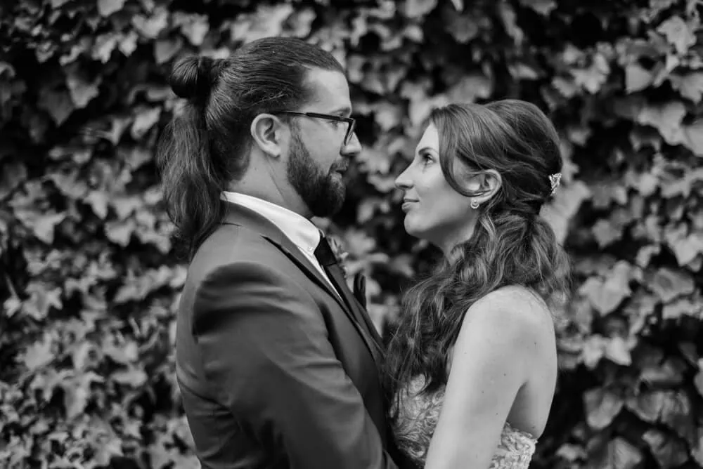 couple nose to nose ivy wall unique groom bun bw