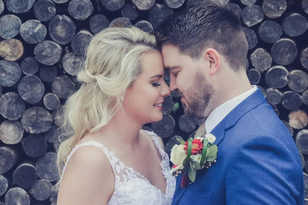 couple nose to nose rustic log wall backdrop