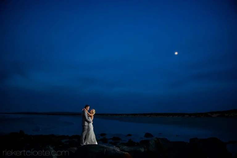 couple ocean rocks moonlit night coastal