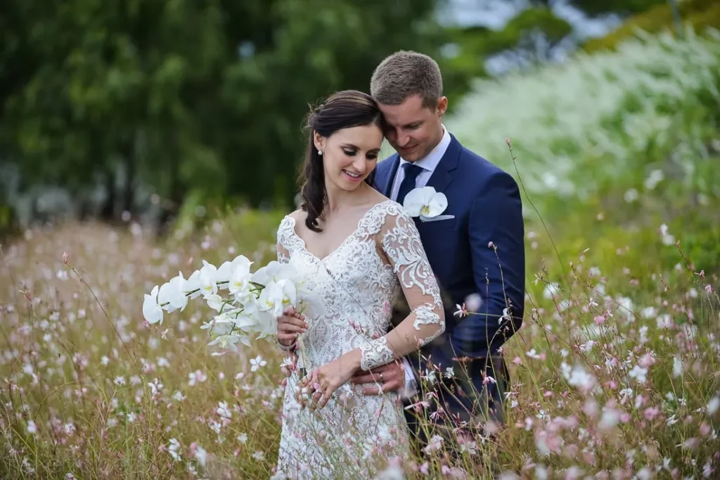 couple pink wildflower field orchid bouquet lace gown