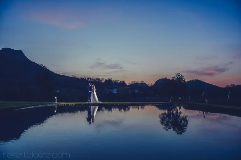 couple reflected calm dam mountain silhouette dusk