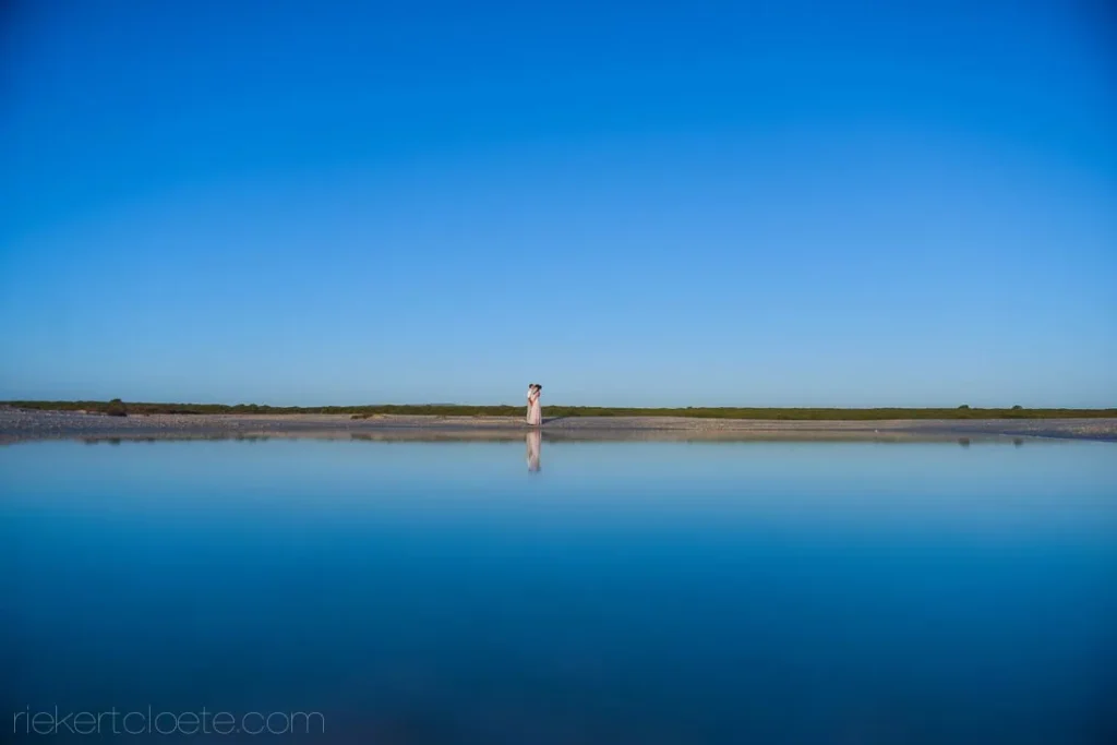 couple salt pan mirror reflection vast blue sky