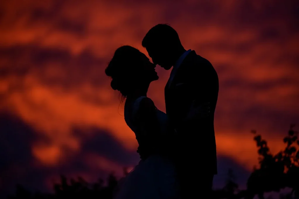 couple silhouette fiery red purple sunset clouds