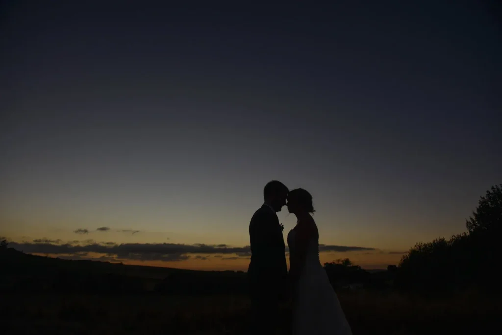 couple silhouette touching foreheads dusk hills