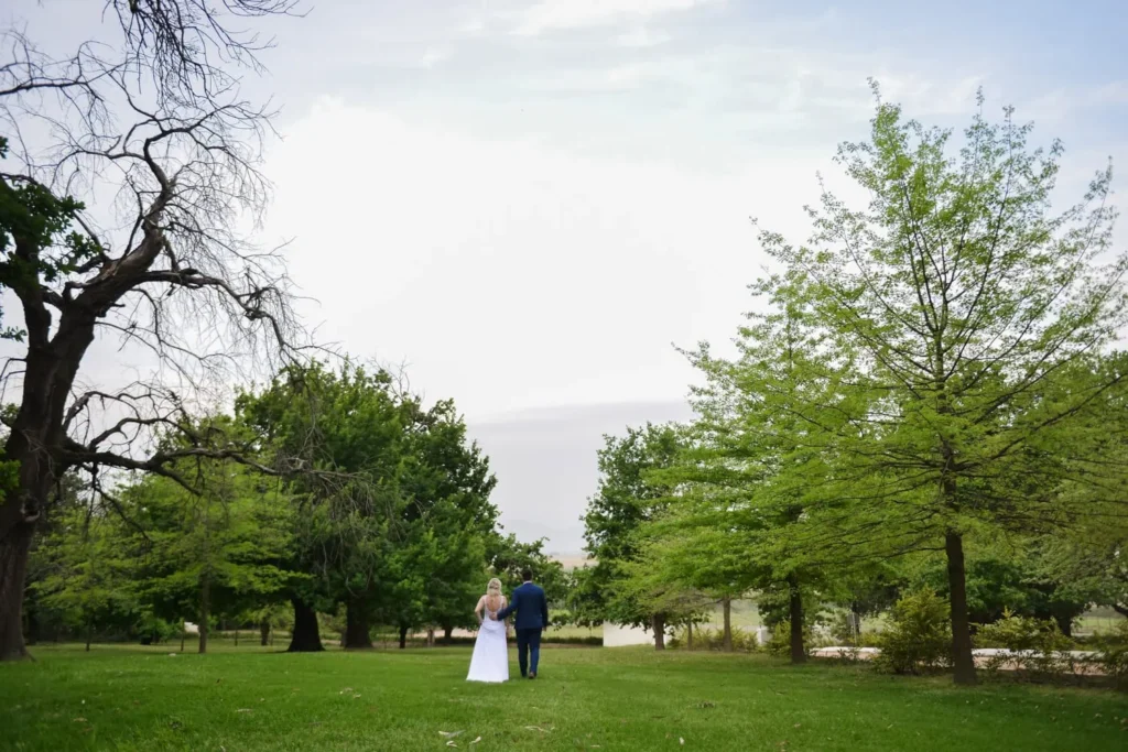 couple strolling wine estate garden mature trees