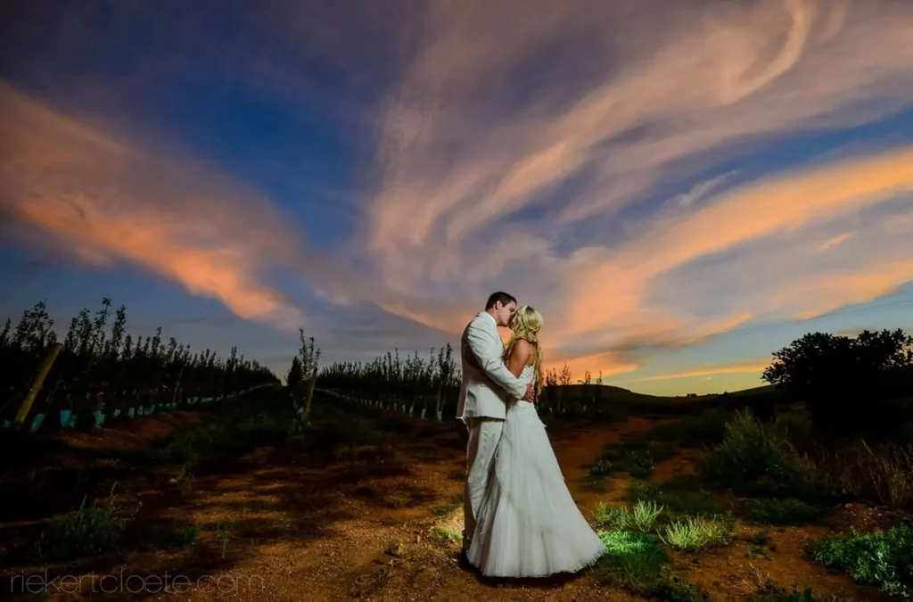couple vineyard swirling sunset sky embrace