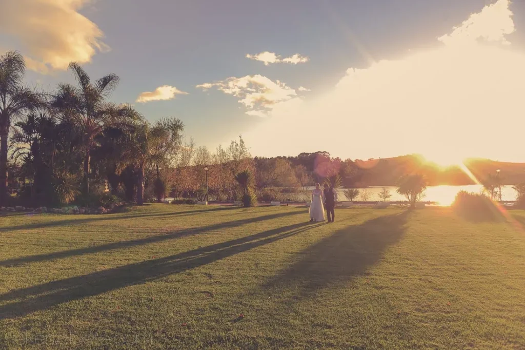 couple walking lush garden palm trees golden hour