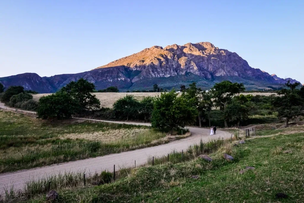 couple winding dirt road mountain valley sunset