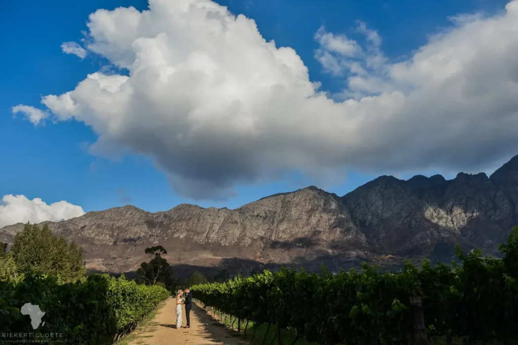 franschhoek vineyard couple path dramatic mountain clouds