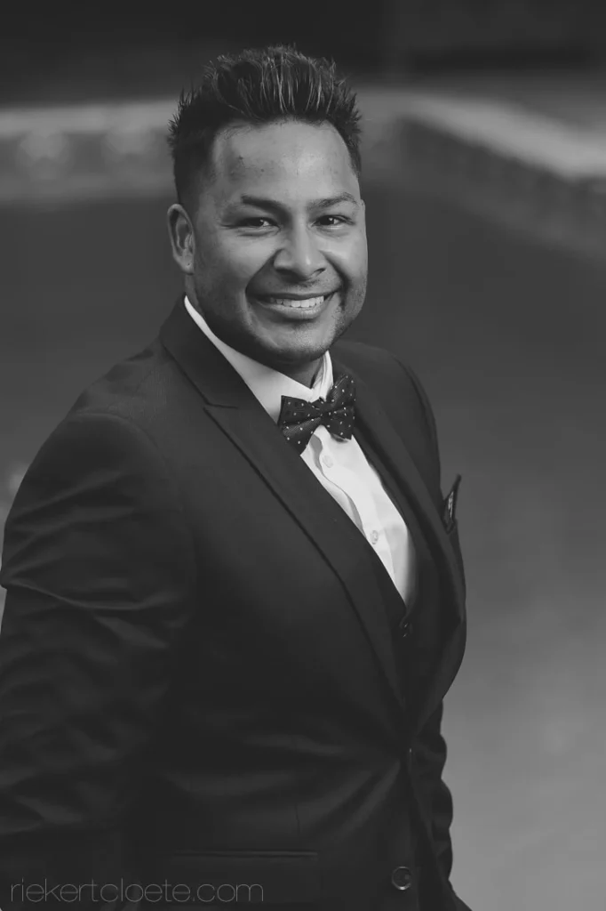 groom black tuxedo bow tie smiling bw portrait