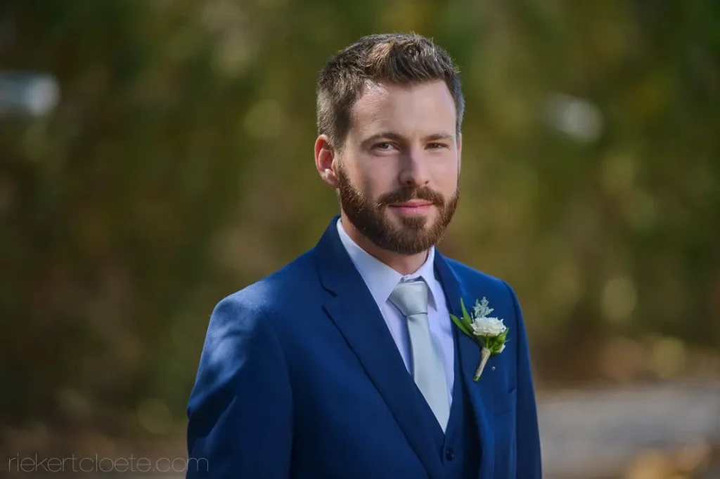 groom blue suit beard rose boutonniere portrait