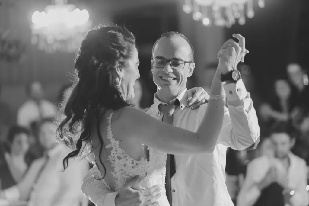 groom glasses laughing first dance chandelier