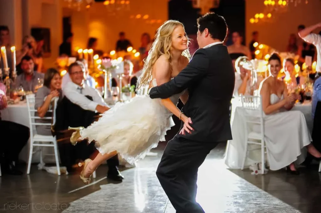 groom lifting bride first dance candlelit reception