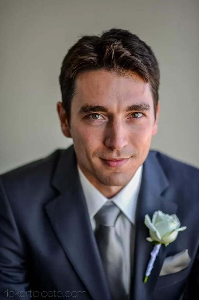 groom navy suit white rose boutonniere portrait