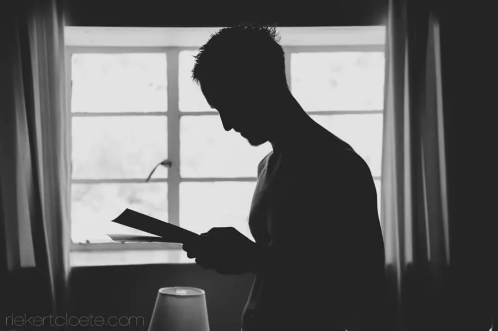 groom reading letter window silhouette wedding