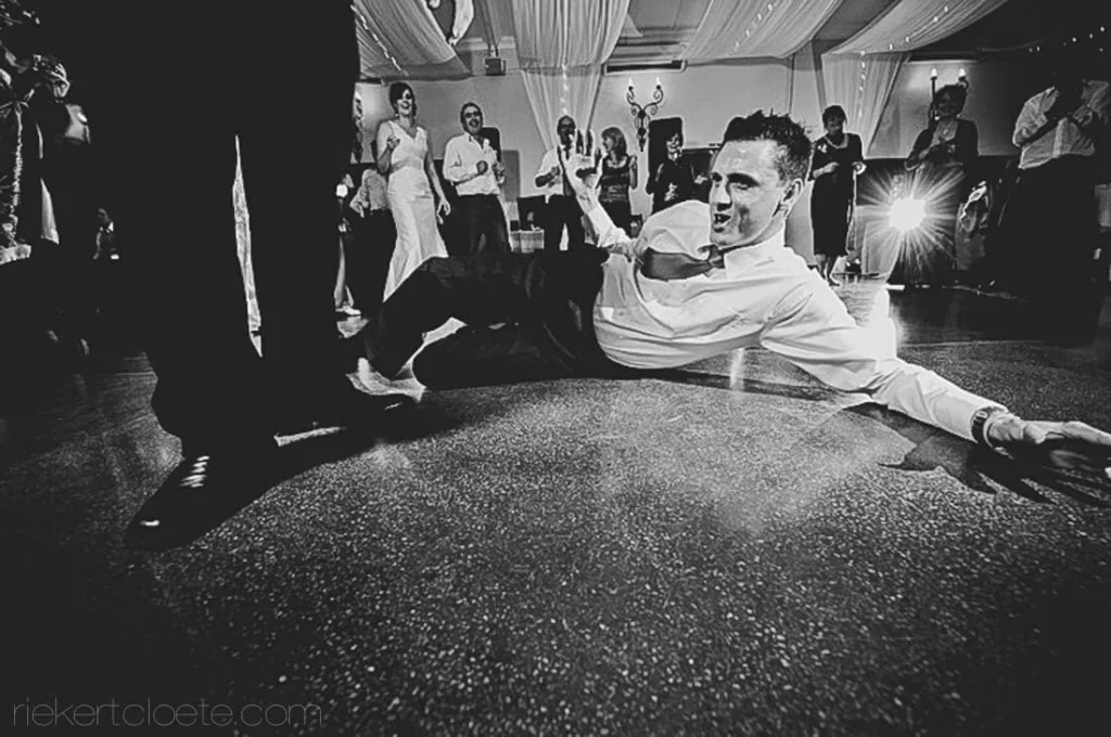 groom sliding dance floor crowd cheering reception