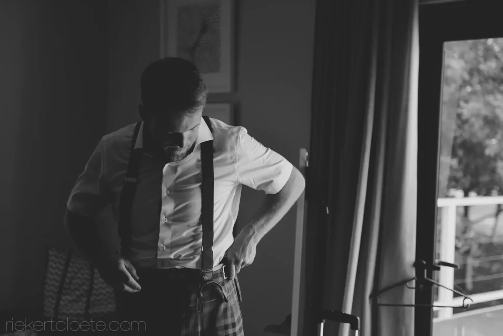 groom suspenders tie getting ready black white
