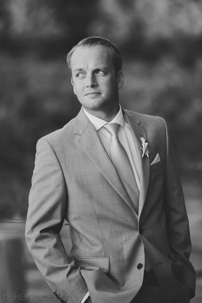 groom tan suit boutonniere dappled outdoor light