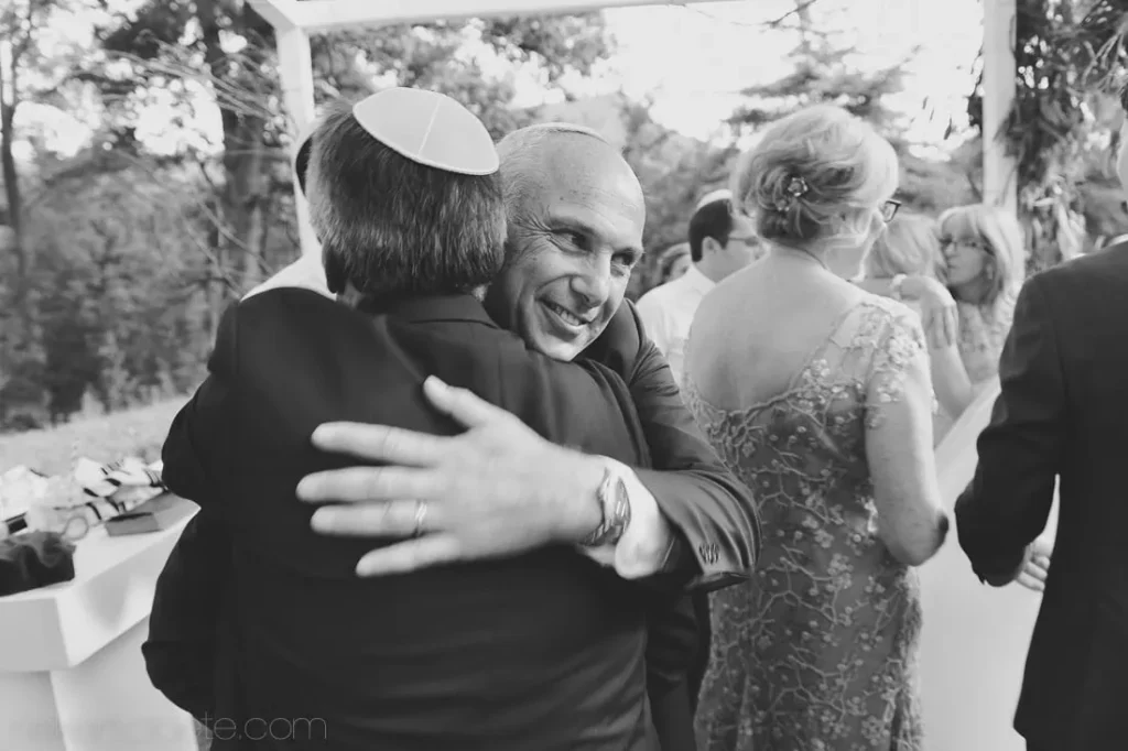 guests heartfelt embrace outdoor jewish wedding ceremony