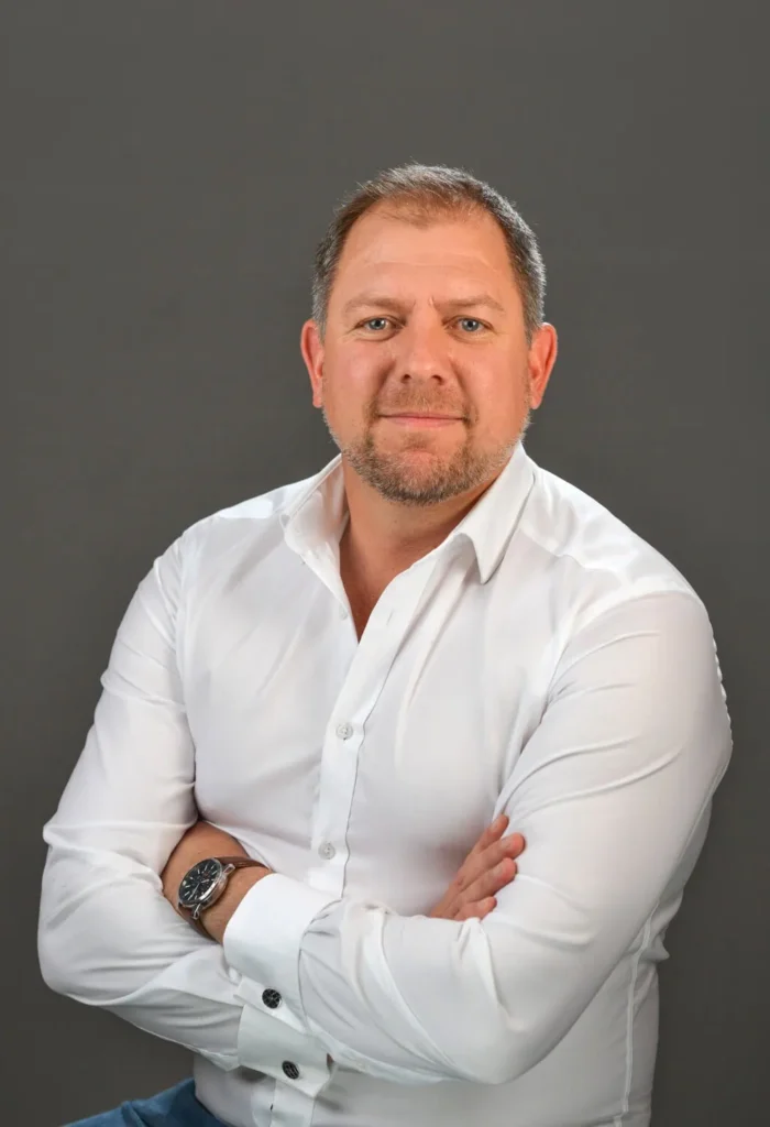 Man, professional and confident, on a dark grey backdrop