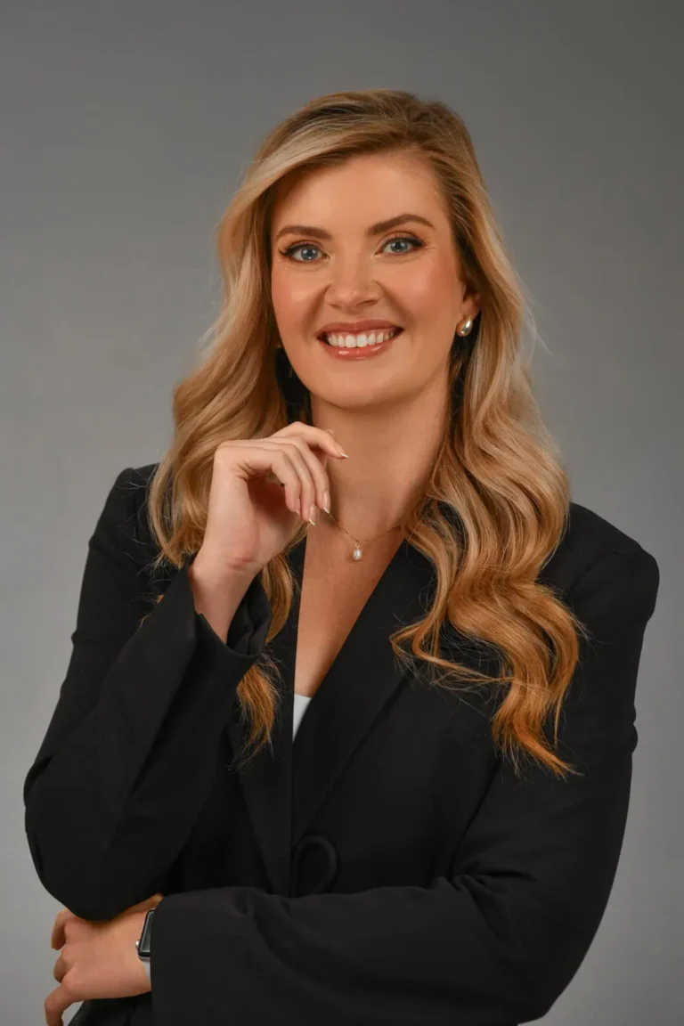 Woman, professional and confident, on a grey backdrop