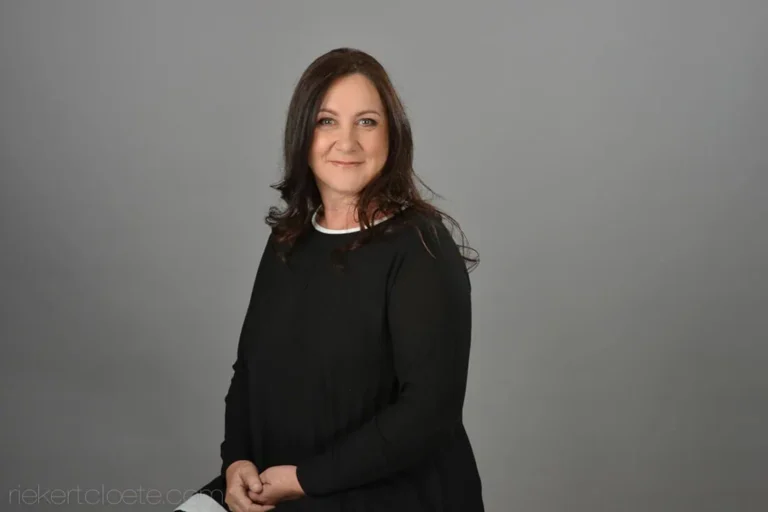 Woman with a confident expression, grey backdrop portrait