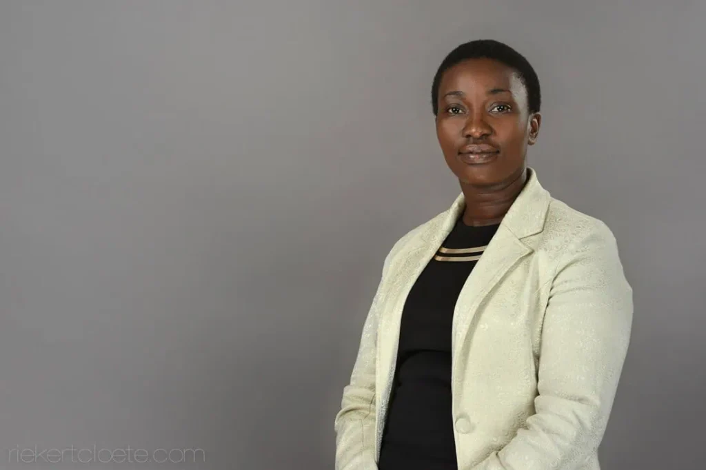 Woman, poised and professional, grey backdrop headshot