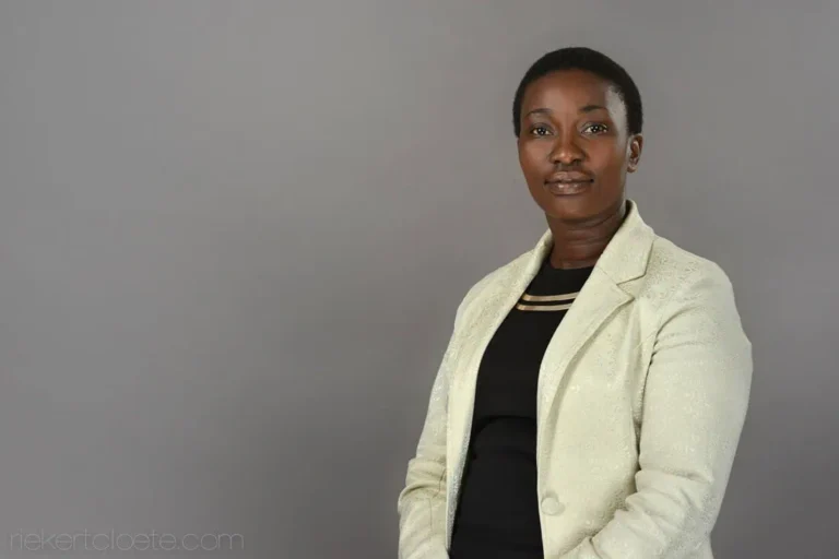 Woman, poised and professional, grey backdrop headshot