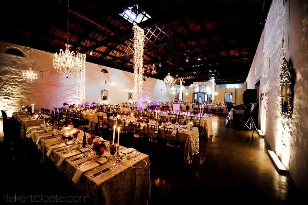 industrial wedding reception exposed brick chandeliers long tables