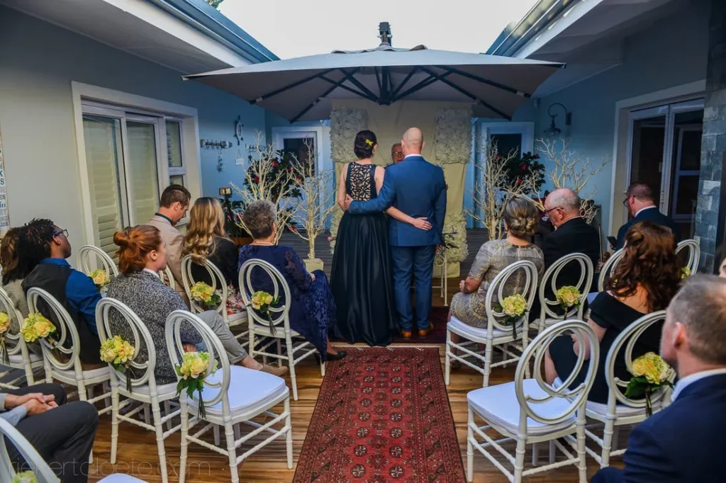 intimate indoor ceremony blue walls ornate chairs runner