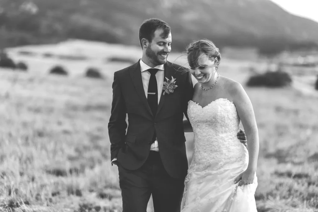 laughing couple walking field black white portrait
