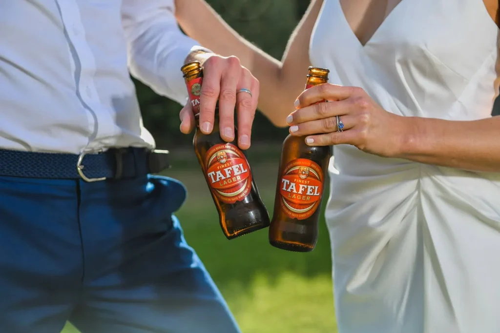 wedding detail couple clinking tafel lager bottles