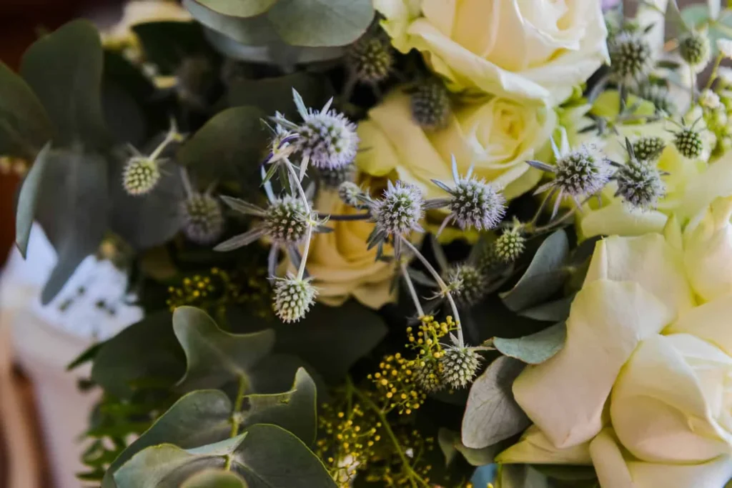 white rose blue thistle eucalyptus bouquet detail