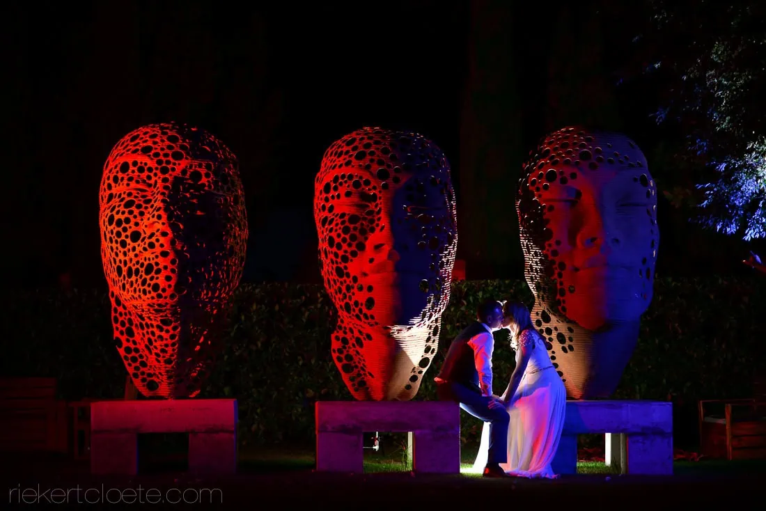 Couple beside an illuminated sculpture in the art garden at Grande Provence at night, Franschhoek