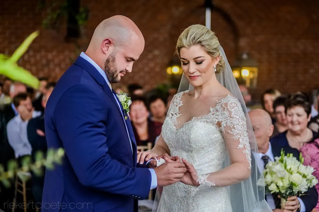 Groom sliding wedding ring onto bride ceremony – Het Vlock Casteel, Riebeek Valley & Swartland