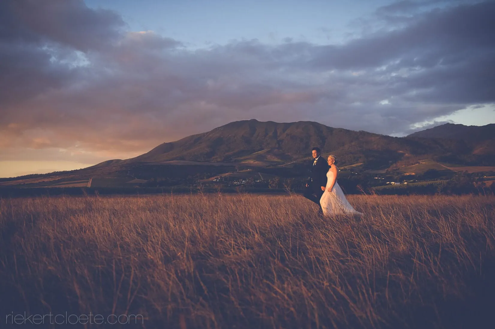 Couple golden grass fields sunset mountain backdrop – Kleinevalleij, Wellington