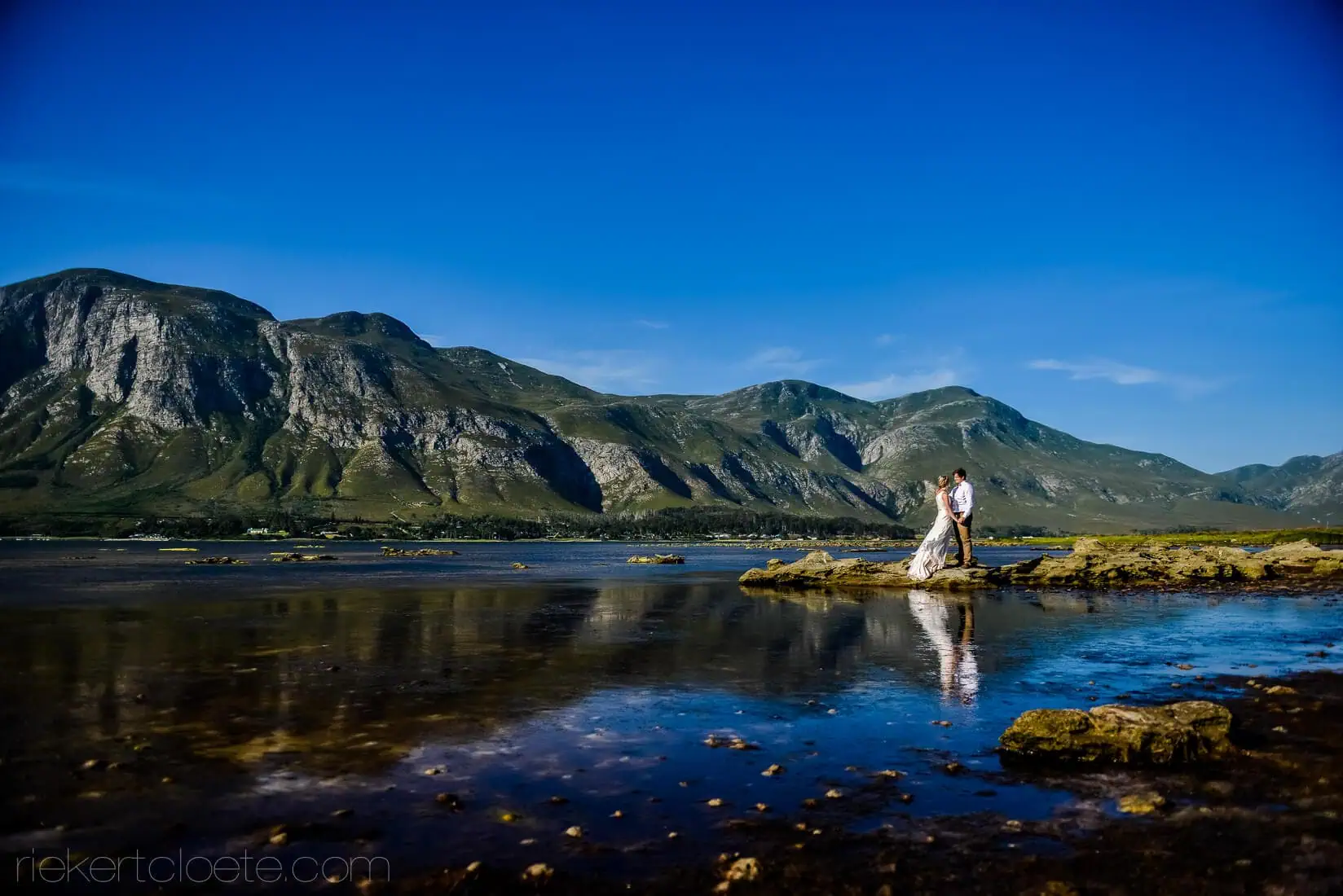 Couple rock tidal pool mountain reflection portrait – Mosaic Lagoon Café, Hermanus