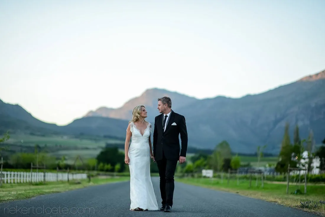 Couple walking vineyard road mountain sunset – Saronsberg Wine Cellar, Tulbagh
