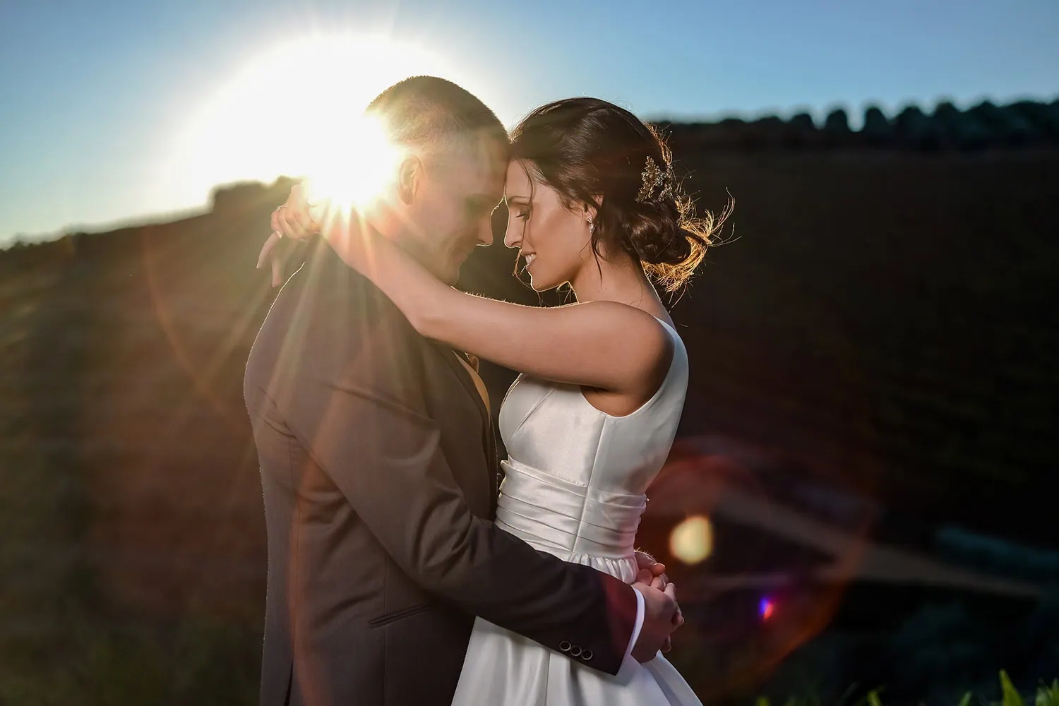 Couple forehead to forehead dramatic sunburst fields – Tokara Restaurant, Stellenbosch