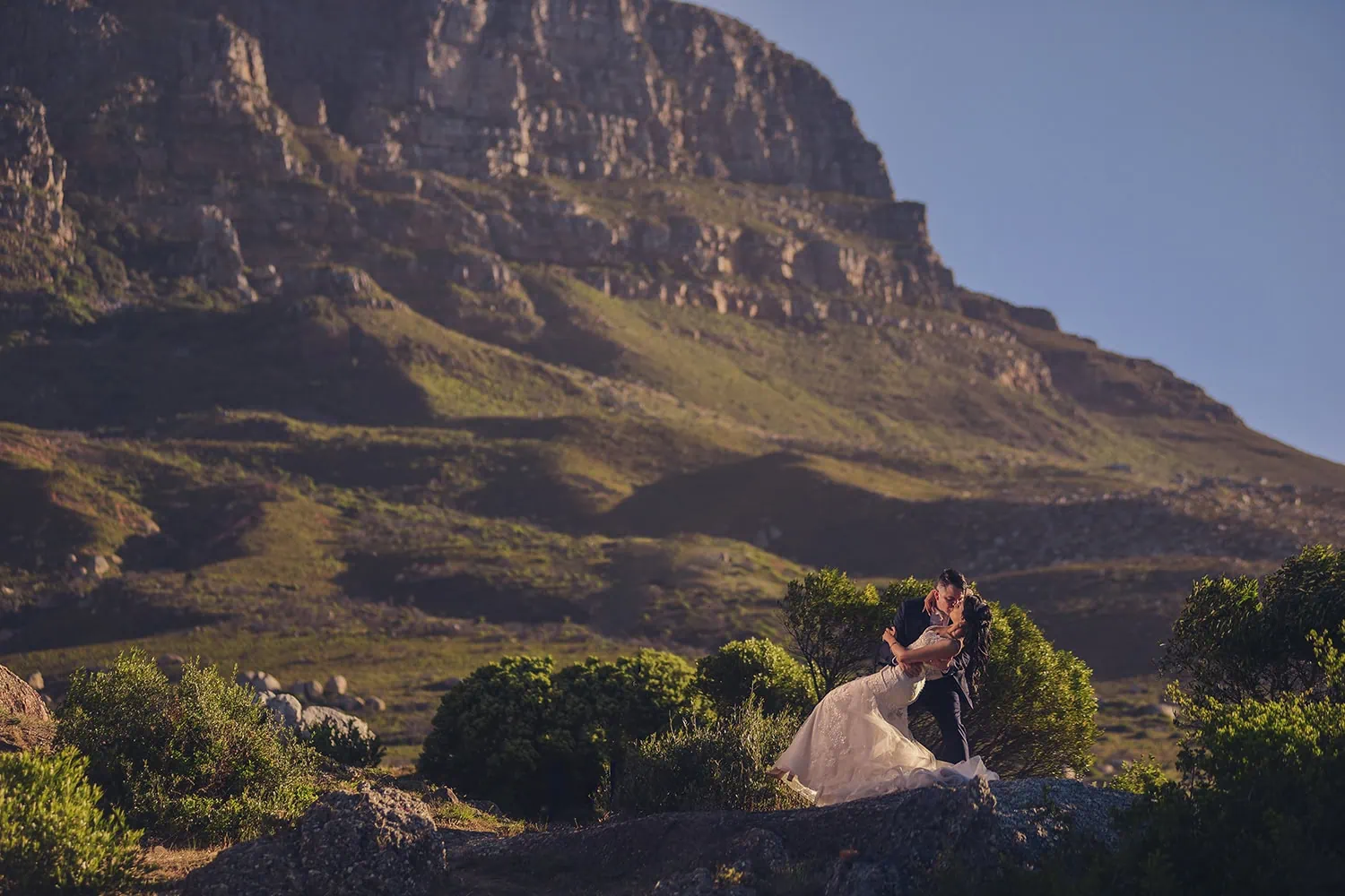 Couple embracing rocky hillside table mountain golden – 12 Apostles Hotel & Spa, Cape Town