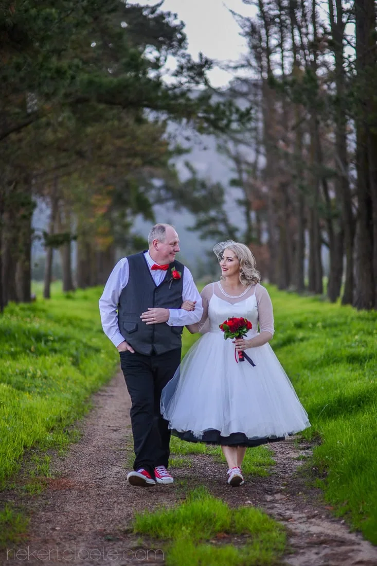 Retro bride groom walking tree lined path – Vondeling Wines, Paarl