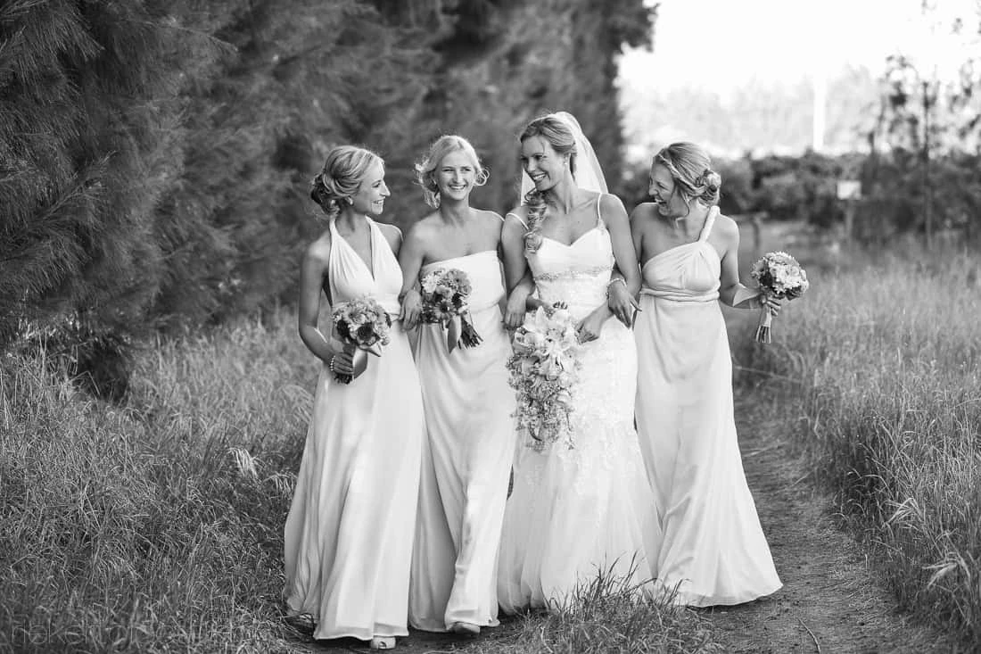 Bride bridesmaids flowing gowns walking path – Vredenheim, Stellenbosch