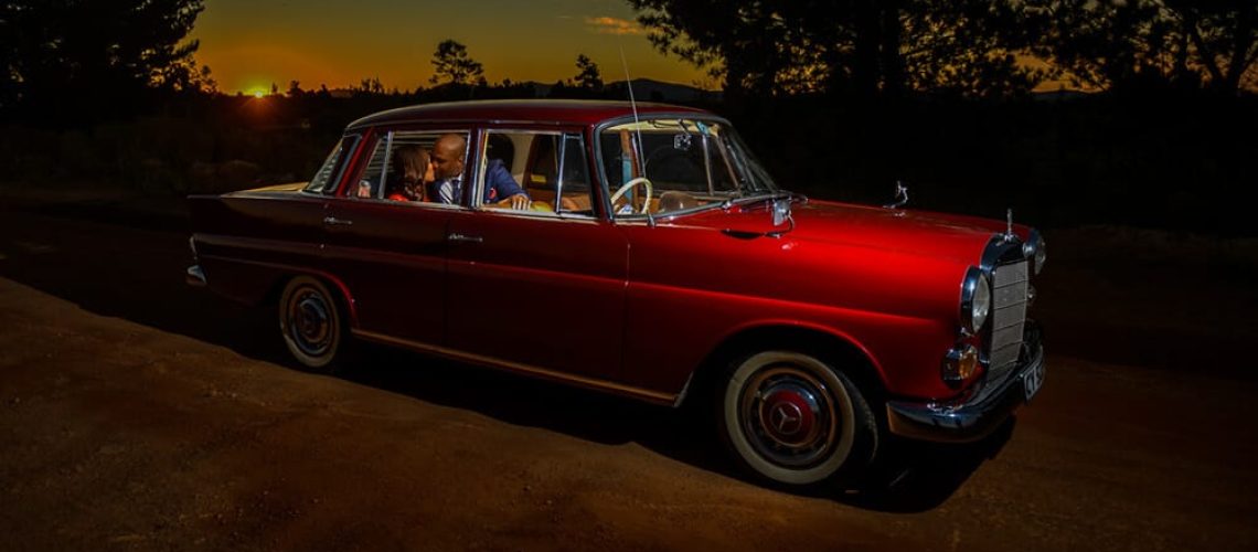 Couple with old wedding car